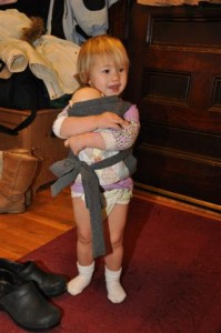 Josie carrying her baby, in old style diaper